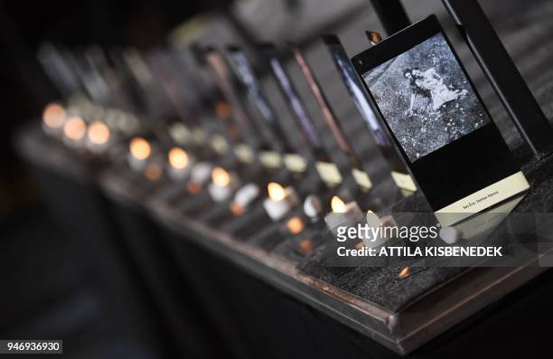 Candles and stones are seen next to photos of Jewish-Hungarian Holocaust victims during a commemoration event at the Holocaust Memorial Center in...
