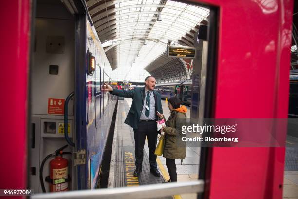 Member of Great Western Railway staff assists a passenger at London Paddington railway station in London, U.K., on Monday, April 16, 2018. British...