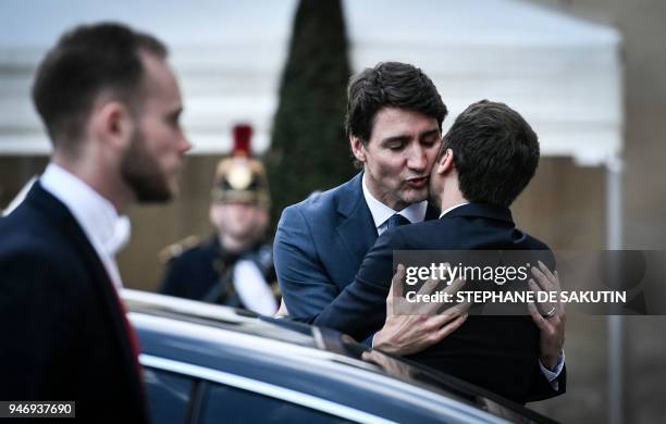 French President Emmanuel Macron hugs Canadian Prime Minister Justin Trudeau as he escorts him following their meeting at the Elysee Palace in Paris,...