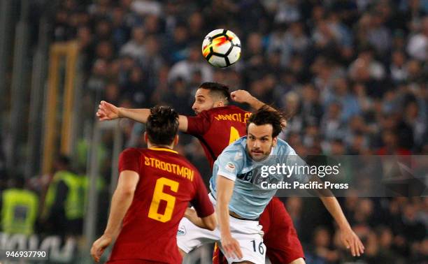 Roma's Kostas Manolas, center, and Lazio's Marco Parolo jump for the ball during the Serie A soccer match between Lazio and Roma at the Olympic...