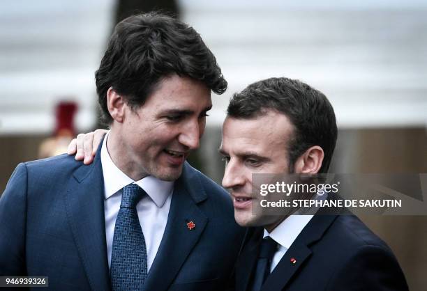 French President Emmanuel Macron and Canadian Prime Minister Justin Trudeau talk as Macron escorts him following their meeting at the Elysee Palace...