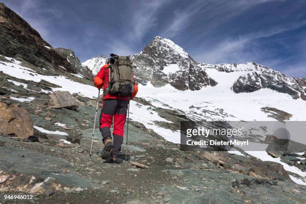 trepador de la montaña en el largo camino hacia grossglockner, alpes austríacos - grossglockner fotografías e imágenes de stock