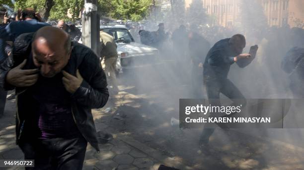 Armenian opposition supporters scatter during clashes with police at a rally in central Yerevan on April 16, 2018. Around a thousand protesters...