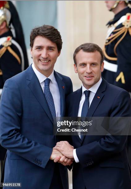 French president Emmanuel Macron accompanies Canadian Prime Minister Justin Trudeau after their meeting at the Elysee Palace on April 16, 2018 in...