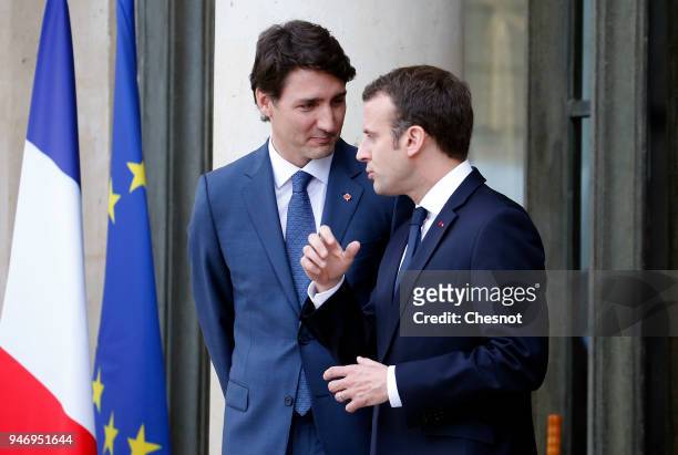 French president Emmanuel Macron accompanies Canadian Prime Minister Justin Trudeau after their meeting at the Elysee Palace on April 16, 2018 in...
