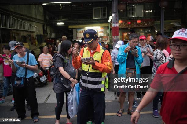 People eat dinner prepared by local volunteers near Xingang Fengtian Temple as festivities take place to mark the arrival of the statue of Mazu where...