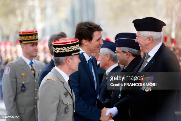 Canadian Prime Minister Justin Trudeau greets war veterans after a wreath laying ceremony on the Tomb of the Unknown Soldier at the Arc de Triomphe...