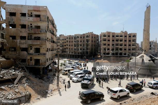 General view shows people gathering at a roundabout surrounded by destroyed buildings in Douma on the outskirts of Damascus on April 16, 2018 during...