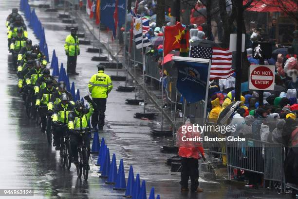 Police on bicycles ride down Boylston Street near the finish line of the 122nd Boston Marathon, April 16, 2018.