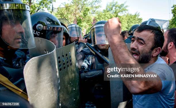 Man shouts in front of Armenian special police forces blocking a street during an opposition rally in central Yerevan on April 16, 2018. An...