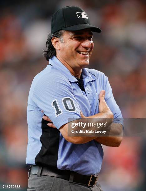 Umpire Phil Cuzzi has talks with manager Jeff Banister of the Texas Rangers as he walks onto the field at Minute Maid Park on April 14, 2018 in...