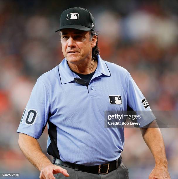 Umpire Phil Cuzzi has talks with manager Jeff Banister of the Texas Rangers as he walks onto the field at Minute Maid Park on April 14, 2018 in...