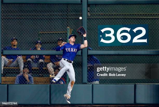 Ryan Rua of the Texas Rangers makes a catch at the wall against the Houston Astros at Minute Maid Park on April 14, 2018 in Houston, Texas.