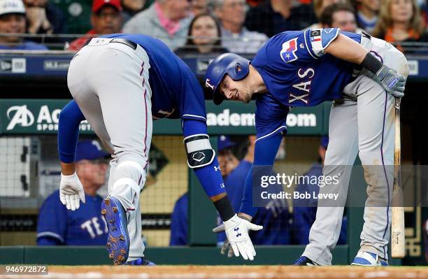 Ronald Guzman of the Texas Rangers receives a low five from Ryan Rua after hitting a home run against the Houston Astros at Minute Maid Park on April...