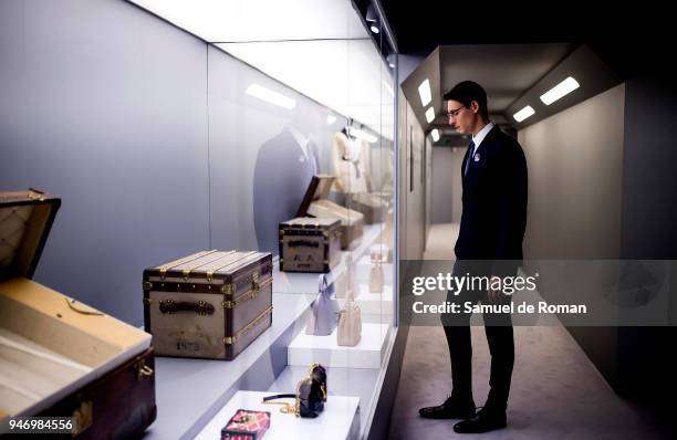 Member of staff observes a work by Lous Vuitton during 'Time Capsule' by Louis Vuitton Exhibition on April 16, 2018 in Madrid, Spain.