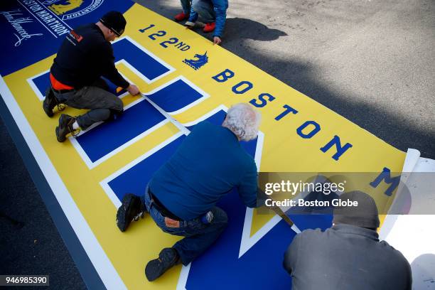 Workers lay down the Finish Line for the 2018 Boston Marathon on Boylston Street in Boston on April 12, 2018.