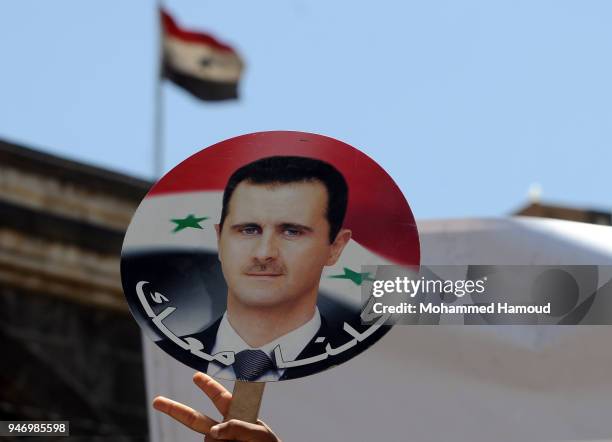 Yemeni man holds a photo of Syrian President Bashar al-Assad during a protest against U.S. Allied missile strikes against Syria outside the Syrian...