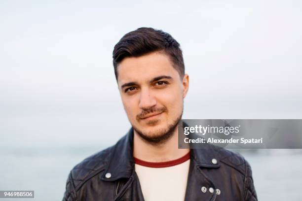 close up portrait of a handsome man with dark hair looking at camera - southern european descent stock pictures, royalty-free photos & images