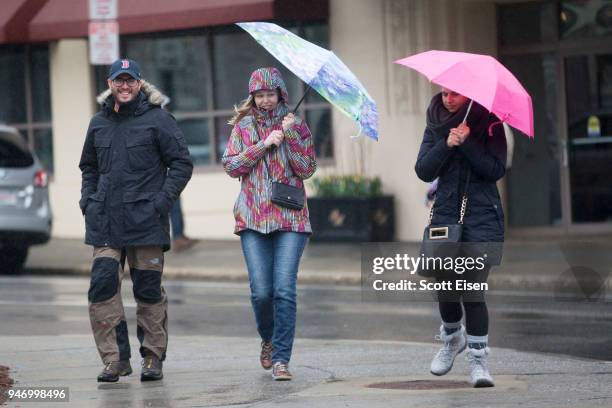 Attendees of the 2018 Boston Marathon hold umbrellas to shield themselves from rain and wind near the 24th mile of the 2018 Boston Marathon on April...