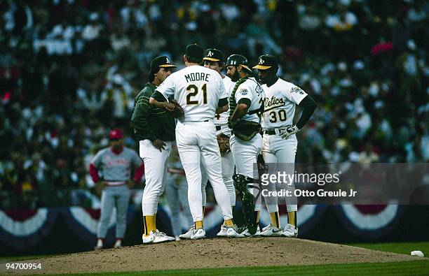 Manager Tony LaRussa, pitcher Mike Moore, Carney Lansford, catcher Terry Steinbach and Willie Randolph of the Oakland Athletics confer on the mound...