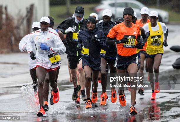 From left, elite men's runners Geoffrey Kirui, Nobert Kigen, Lemi Berhanu and Abdihakem Abdirahman run through the rain along the route of the Boston...