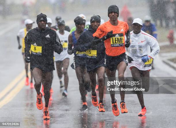 From left, elite men's runners Felix Kandie, Nobert Kigen, Lemi Berhanu and Geoffrey Kirui run through the rain along the route of the Boston...