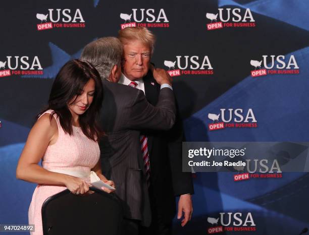 President Donald Trump speaks with Maximo Alvarez next to Irina Vilatino during a roundtable discussion about the Republican $1.5 trillion tax cut...