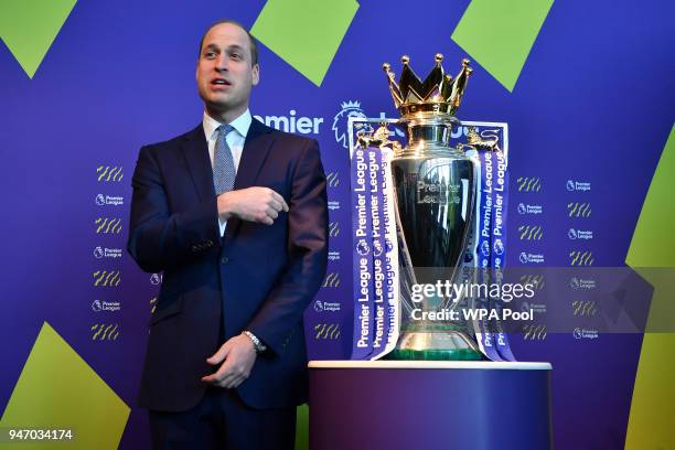 Prince William, Duke of Cambridge points to the English Premier League football trophy during a 'Welcome to the UK' reception on the opening day of...