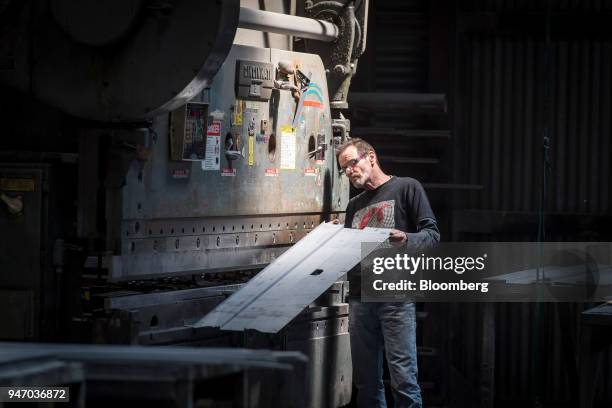 Worker checks a bend on a piece of metal made using the press brake at the Metal Manufacturing Co. Facility in Sacramento, California, U.S., on...