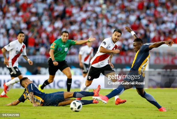 Ignacio Scocco of River Plate fights for the ball with Joaquin Pereyra and Oscar Cabezas of Rosario Central during a match between River Plate and...