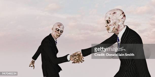trust in business concept: zombie business men shaking hands - zombie walk - fotografias e filmes do acervo