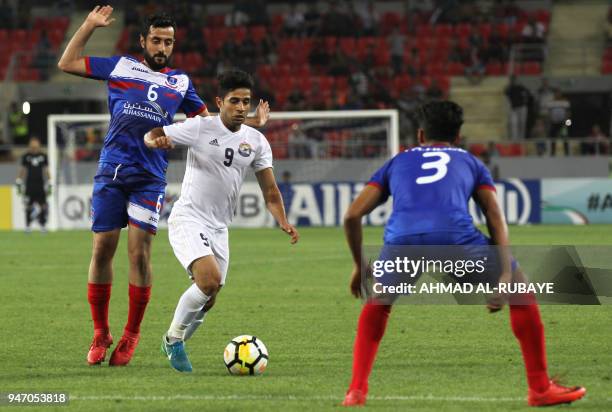 Al-Zawraa's Hussein Ali dribbles the ball as Manama's Masoud Qambar defends during the AFC Cup football match between Iraq's Al-Zawraa club and...