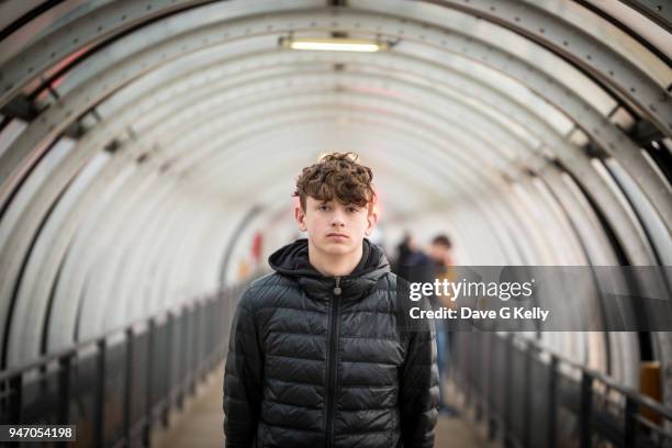 teenage boy in a glass tunnel looking at camera - serious teenager boy stock-fotos und bilder