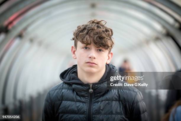 teenage boy in a glass tunnel looking at camera - boy portrait stock-fotos und bilder