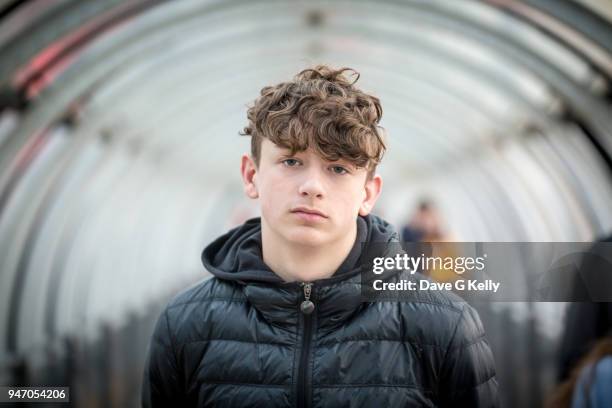 teenage boy in a glass tunnel looking at camera - young face serious at camera stockfoto's en -beelden