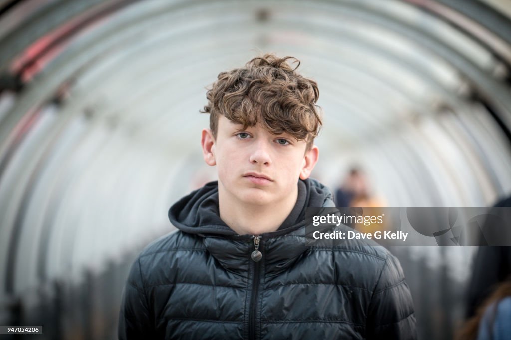 Teenage boy in a glass tunnel looking at camera