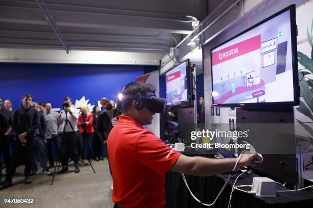 Rogers Communications Inc. Employee uses a virtual reality headset to shop at a virtual store during a demonstration of 5G wireless network...