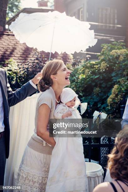 outdoors traditionnal baby baptism with family. - baptism girl stock pictures, royalty-free photos & images