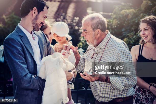 outdoors baby baptism with family and celebrant. - baptism girl stock pictures, royalty-free photos & images