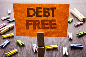Handwritten text sign showing Debt Free. Business concept for Credit Money Financial Sign Freedom From Loan Mortage written on sticky Note on the wooden background.