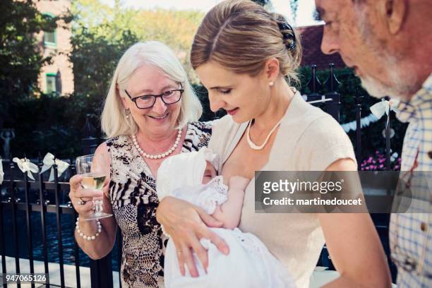 family portrait at traditionnal baby baptism outdoors. - christian baptism stock pictures, royalty-free photos & images