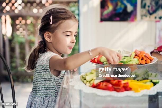 cute little girl eating raw vegetables at a buffet. - dipping stock pictures, royalty-free photos & images