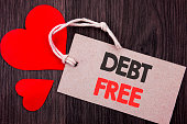 Handwriting Announcement text showing Debt Free. Business concept for Credit Money Financial Sign Freedom From Loan Mortage written on Price tag with Red words on the wooden background.