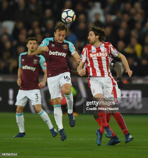 Mark Noble of West Ham United and Joe Allen of Stoke City battle for possession in the air during the Premier League match between West Ham United...