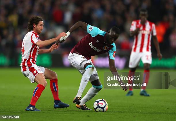Joe Allen of Stoke City and Cheikhou Kouyate of West Ham United battle for possession during the Premier League match between West Ham United and...