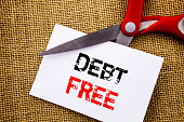 Handwriting text showing Debt Free. Conceptual photo Credit Money Financial Sign Freedom From Loan Mortage written on Sticky Note Paper Cutting by Scissors on the textured background