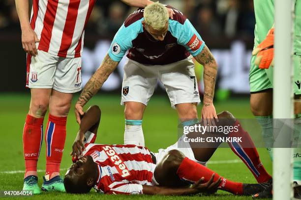 Stoke City's French defender Kurt Zouma lays injured during the English Premier League football match between West Ham United and Stoke City at The...