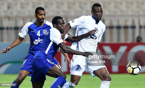 Saudi's al-Hilal players Abdulmalek Al Khaibri and Abdullah al-Zoari vie for the ball against Iran's Esteqlal club player Mame Baba Thiam during the...