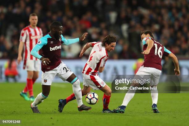 Arthur Masuaku of West Ham United, Joe Allen of Stoke City and Mark Noble of West Ham United battle for possession during the Premier League match...