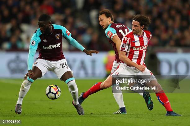 Arthur Masuaku of West Ham United, Joe Allen of Stoke City and Mark Noble of West Ham United battle for possession during the Premier League match...